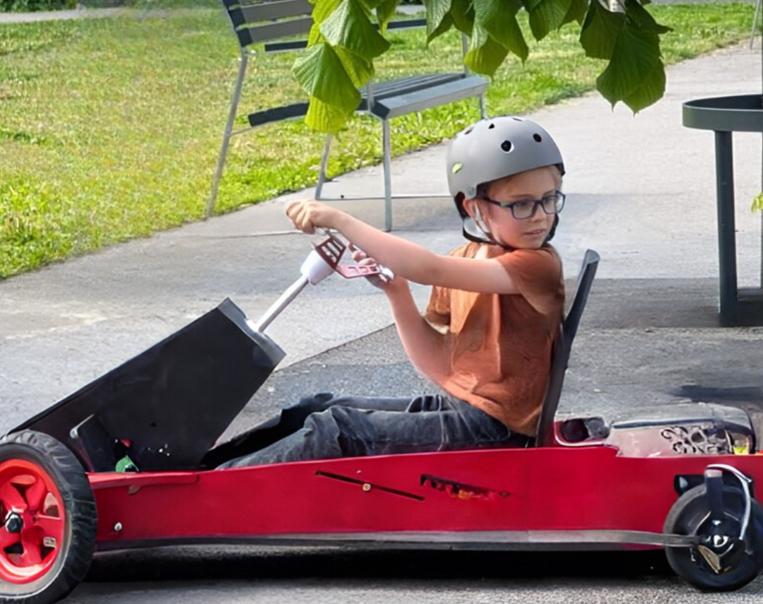 Student driving red solar kart